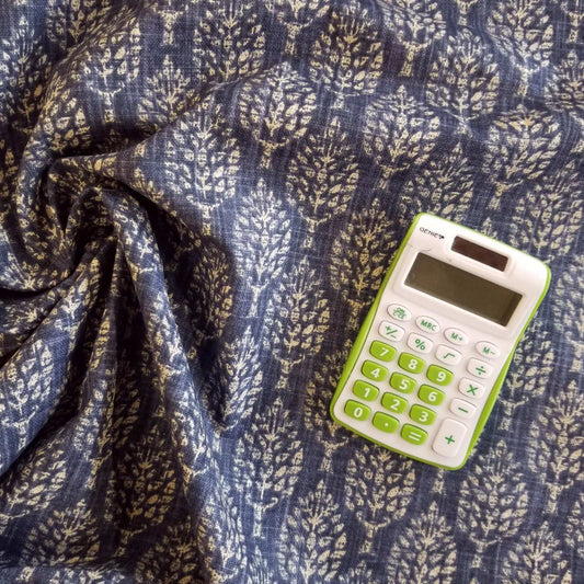 A calculator on a curtain fabric featuring a leaf shape block print on a dark blue background
