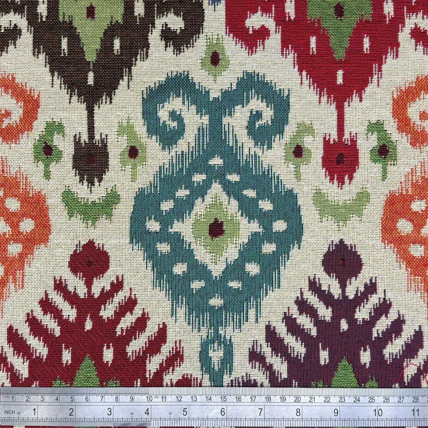 Tapestry fabric with a multicolour Ikat design and a rule for scale