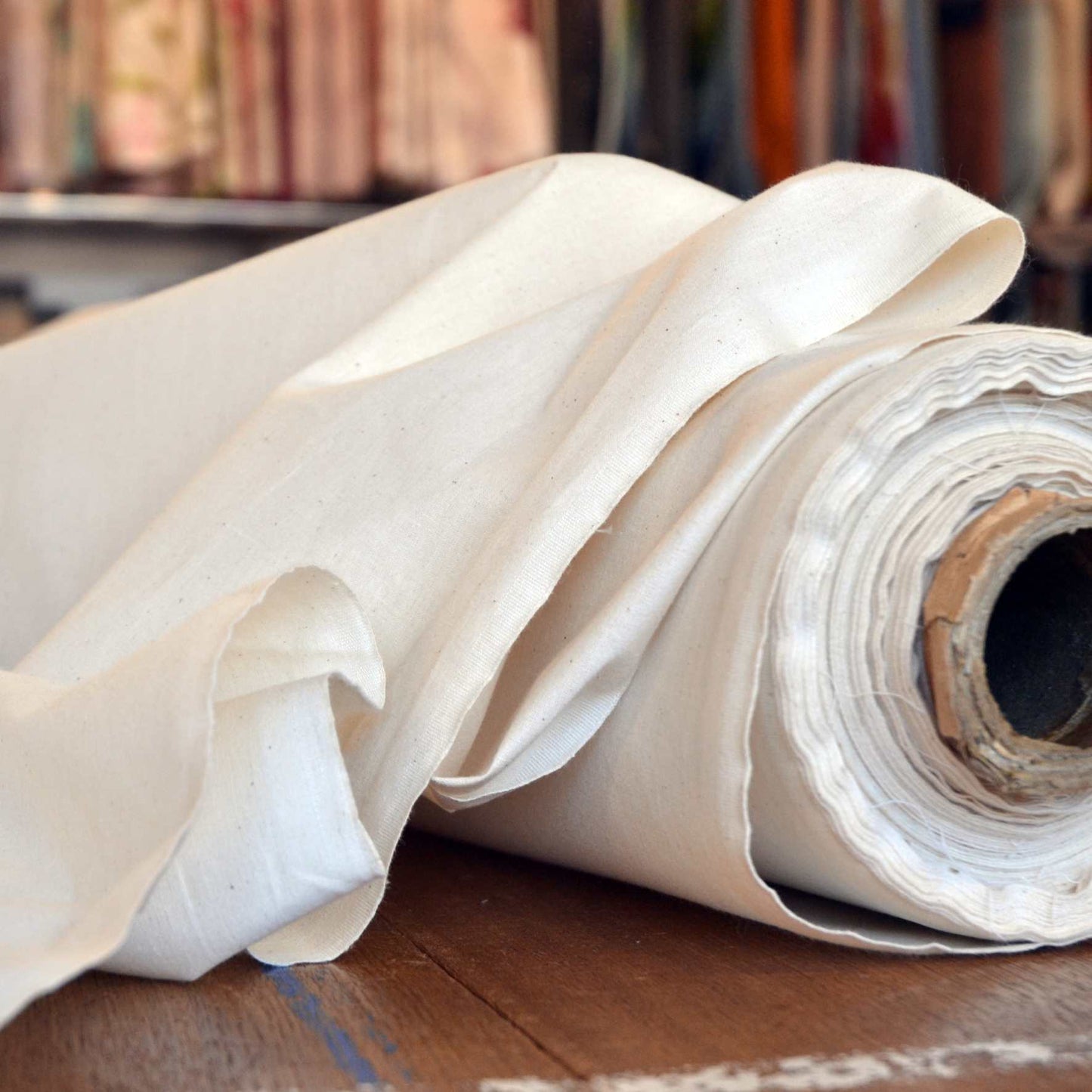A roll of lightweight natural undyed calico fabric