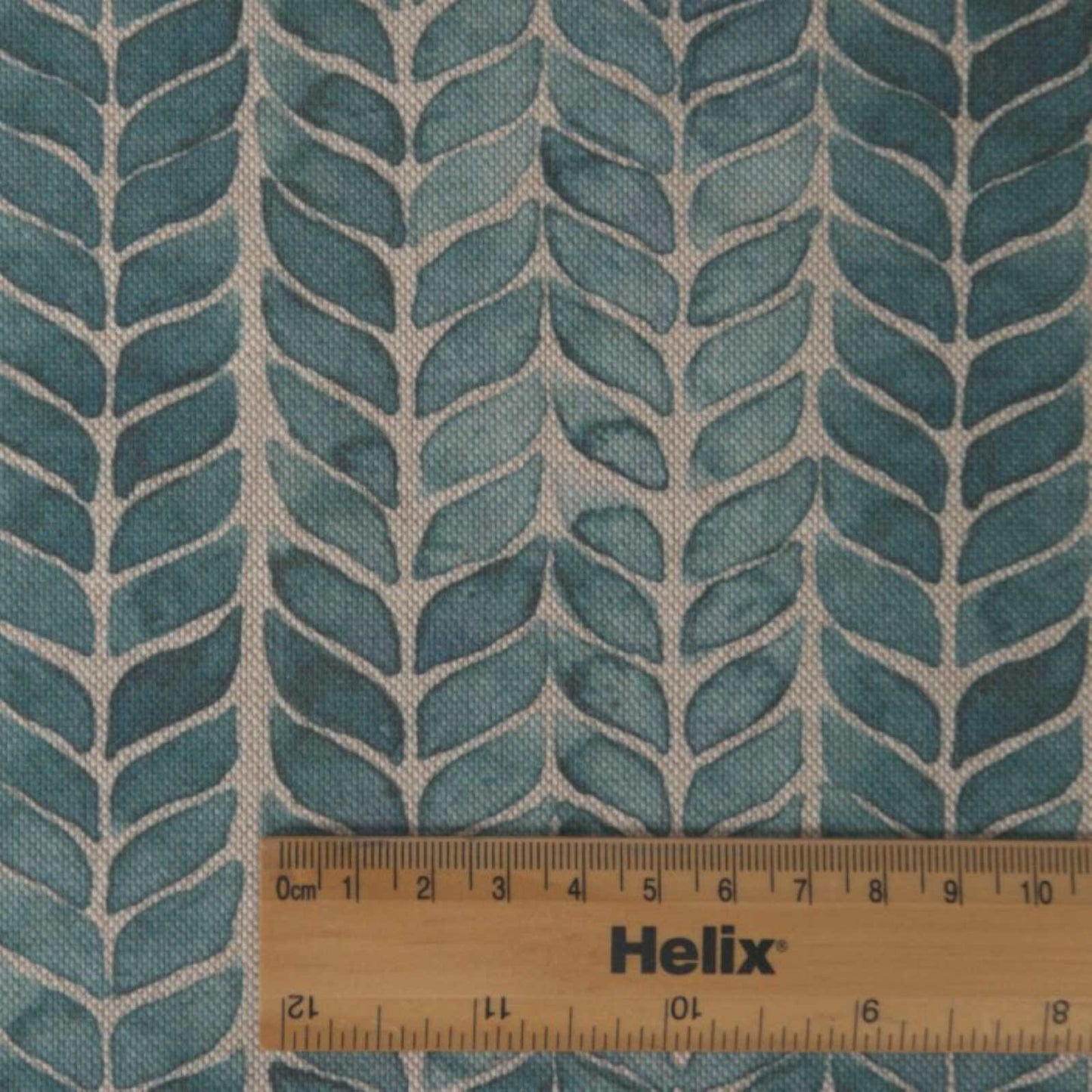 Teal blue fabric with rule showing the size of the leaf print stripes