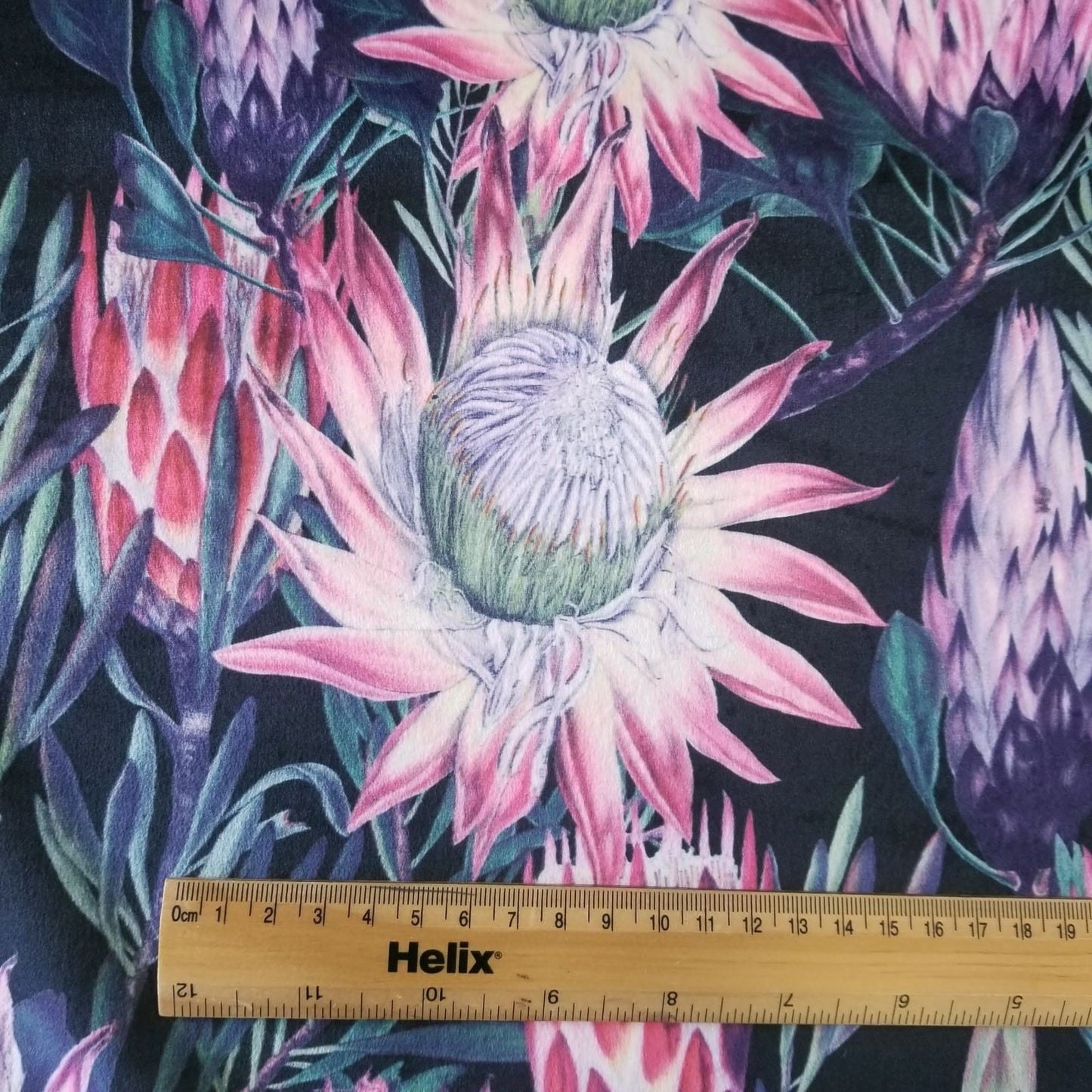 Black Velvet fabric with a rule to show the size of the large pink floral pattern