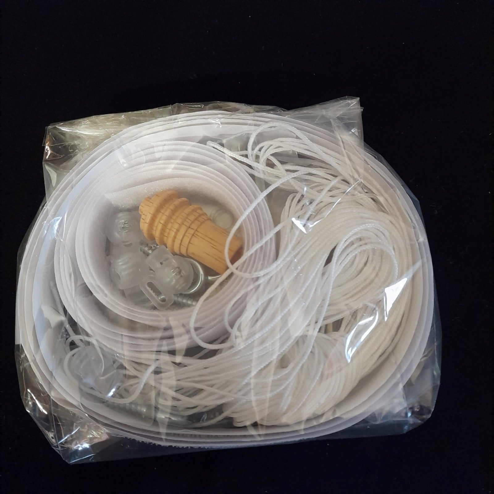 Cellophane package containing roman blind kit components such as velcro, cleat, acorn etc