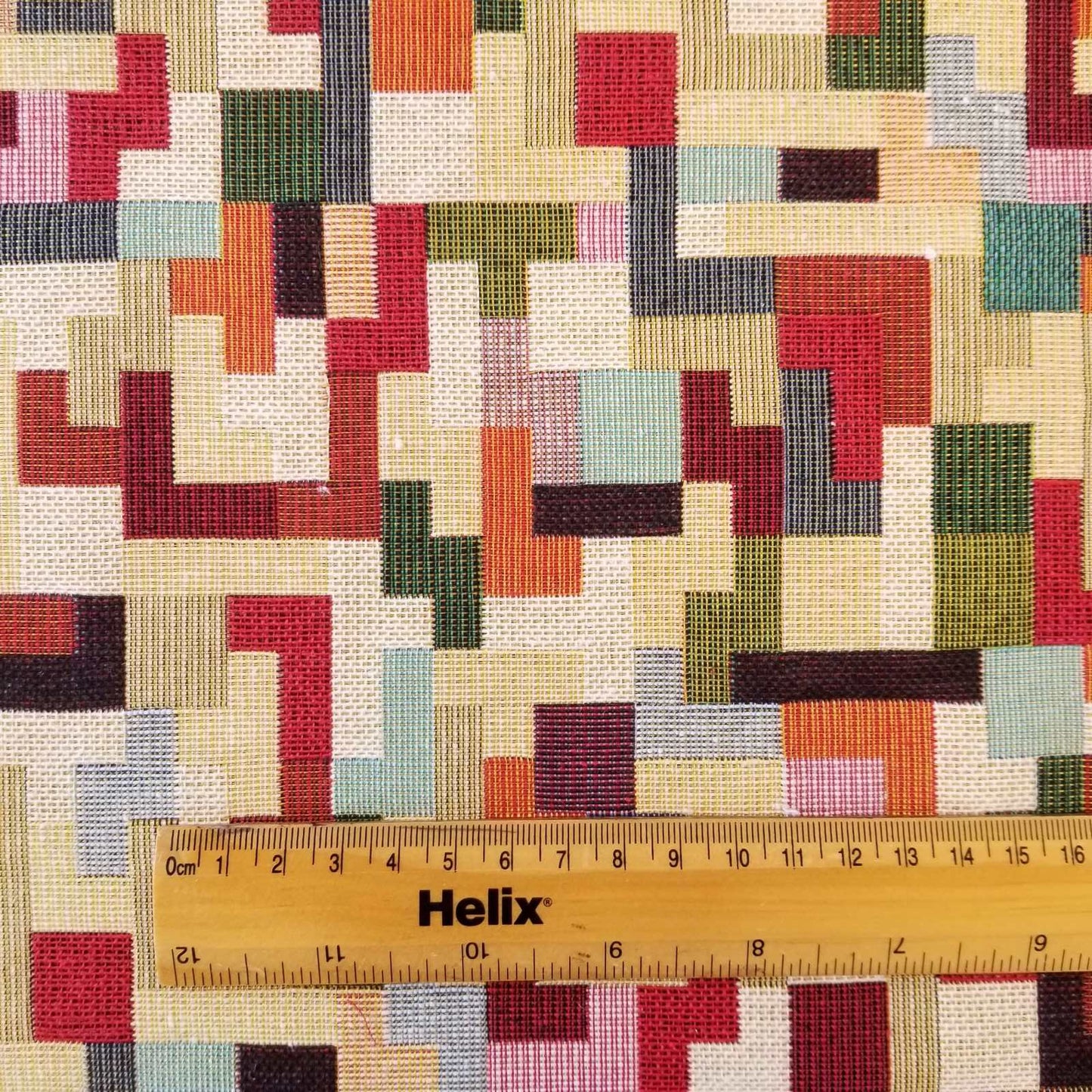 Tapestry fabric with a rule showing scale of multicolour tetris design
