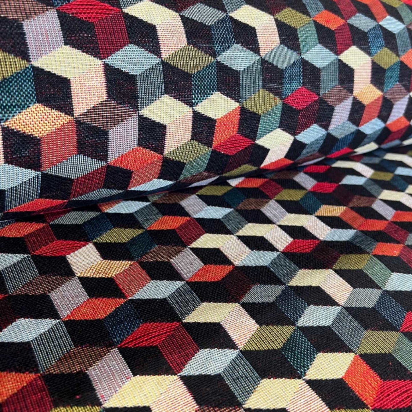 A roll of multicolour tapestry fabrics with a tumbling blocks pattern