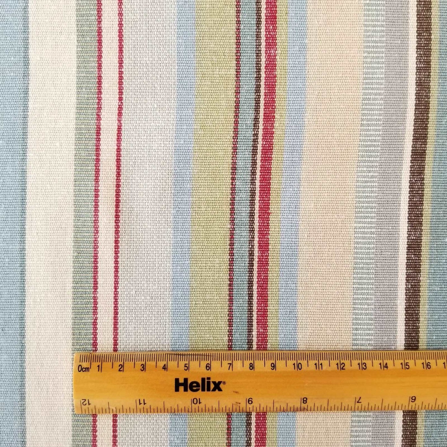 Cotton fabric with a rule showing scale of woven blue green stripe design