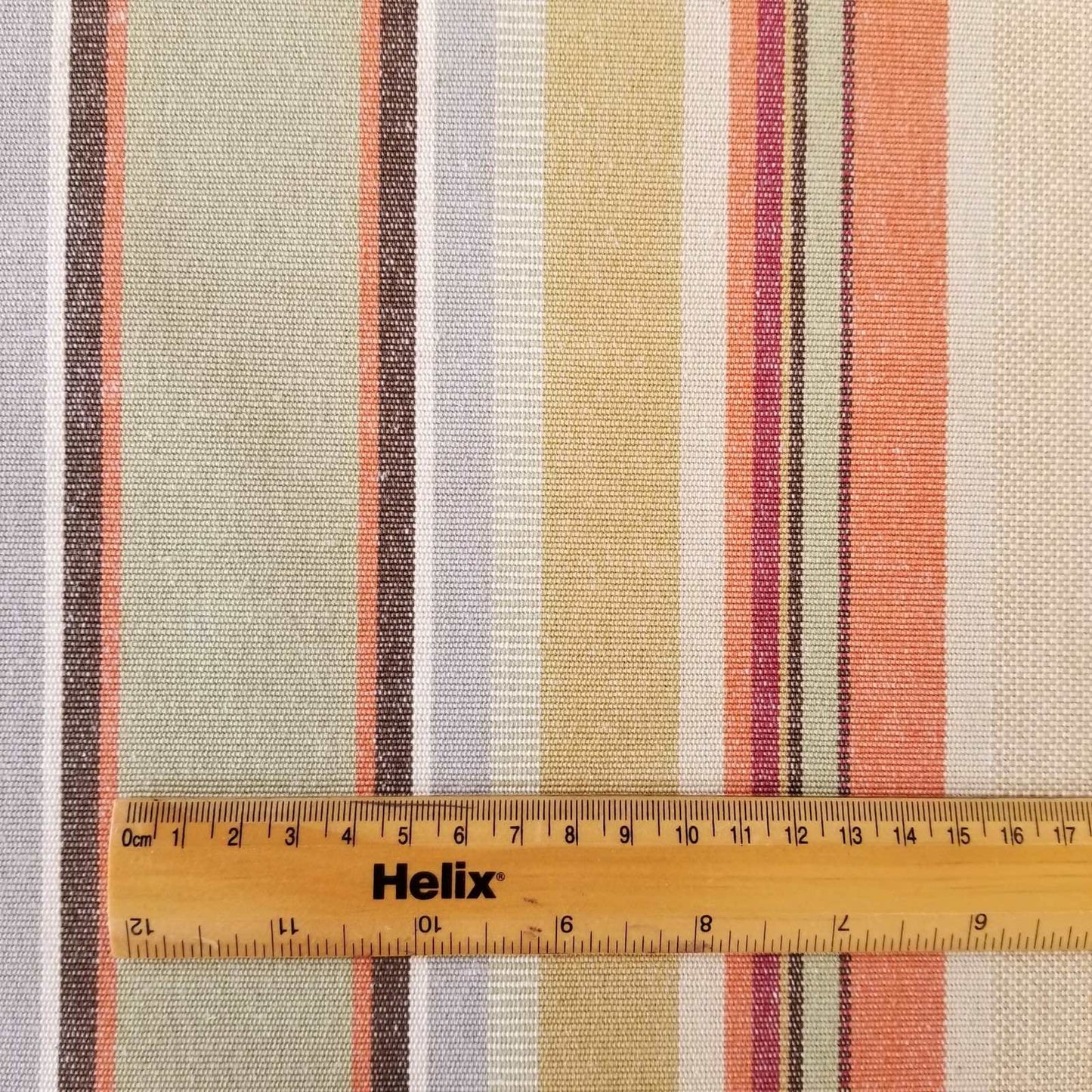 Cotton fabric with a rule showing scale of woven terracotta stripe design