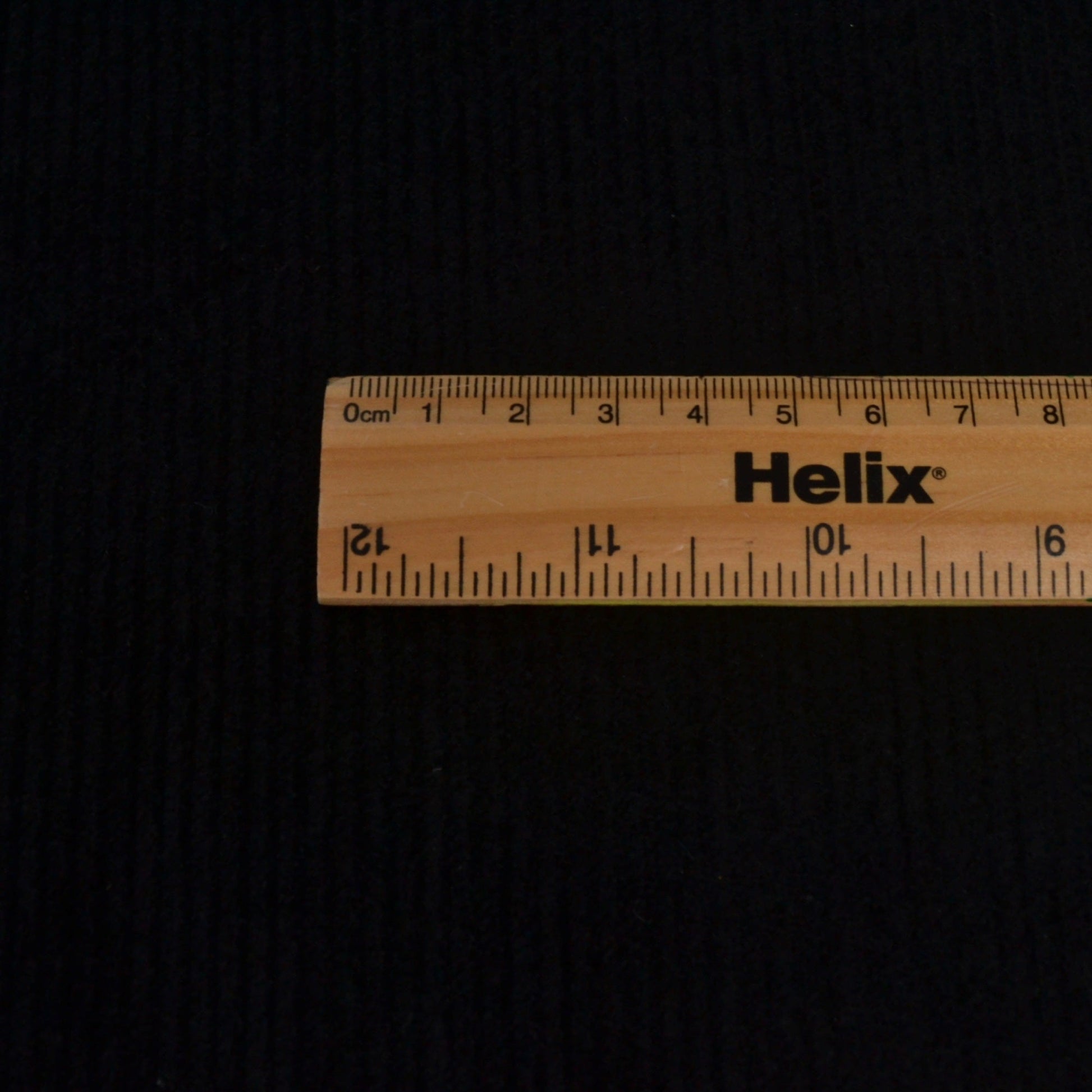 Black Cotton corduroy with a ruler showing size of the ribs on the fabric