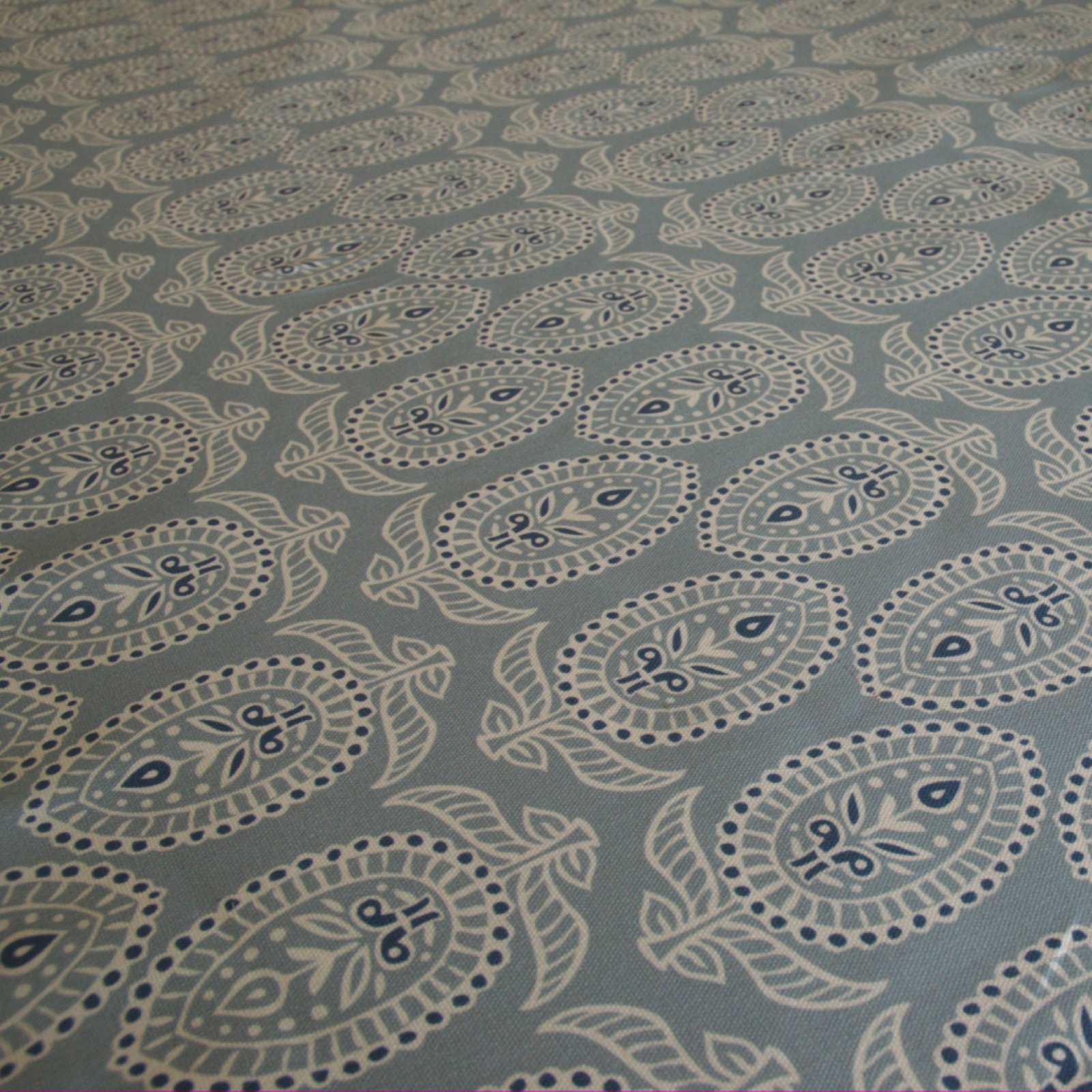 Curtain fabric with block print design on duck egg blue background