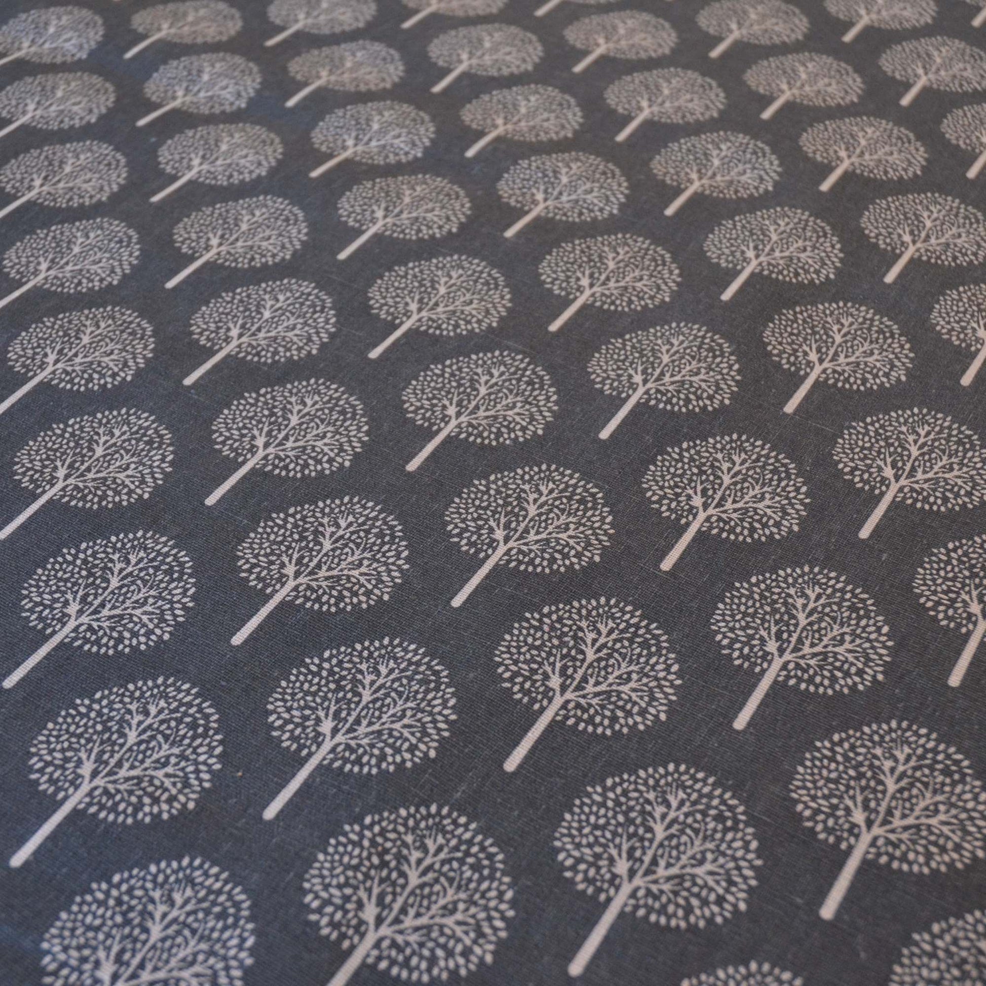 Dark Grey curtain or upholstery fabric with lighter trees, fabric shown at an angle