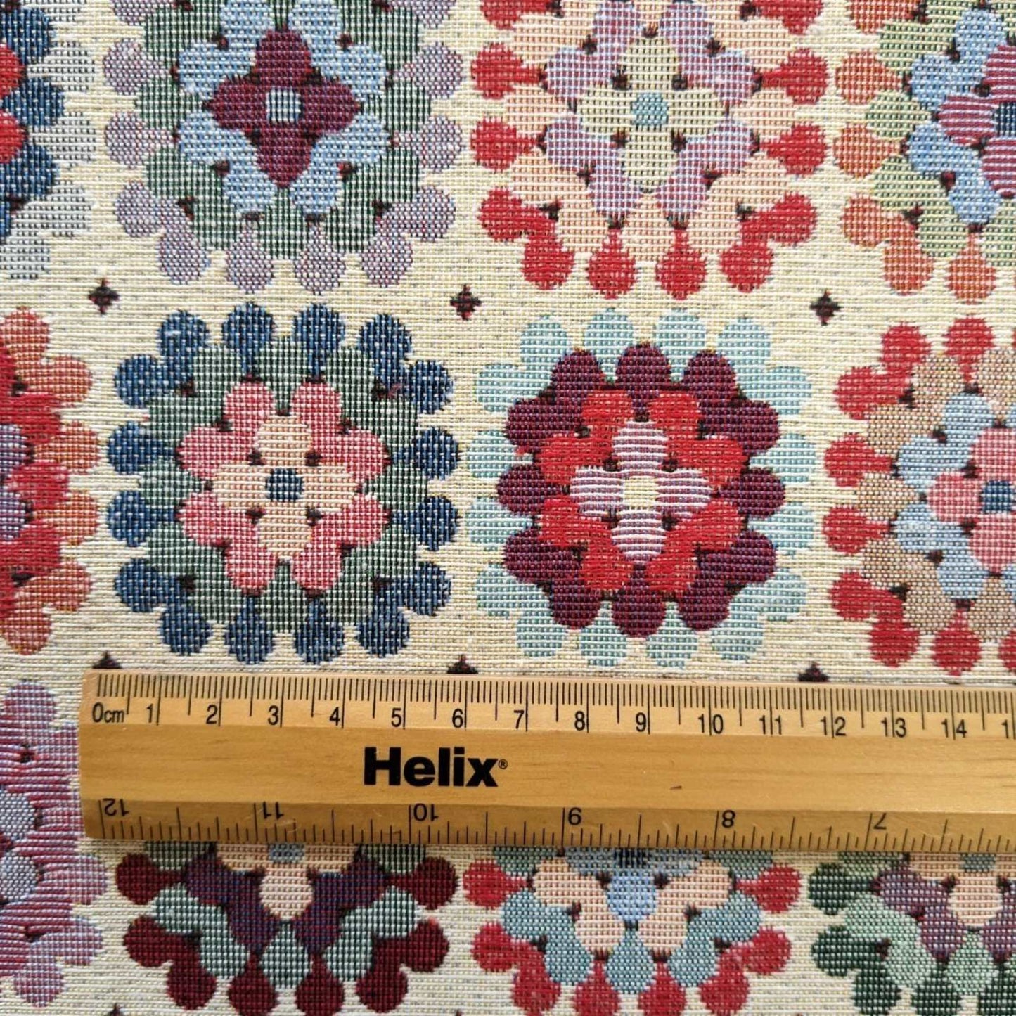 Multicolour tapestry fabric with a granny square design and a rule for scale