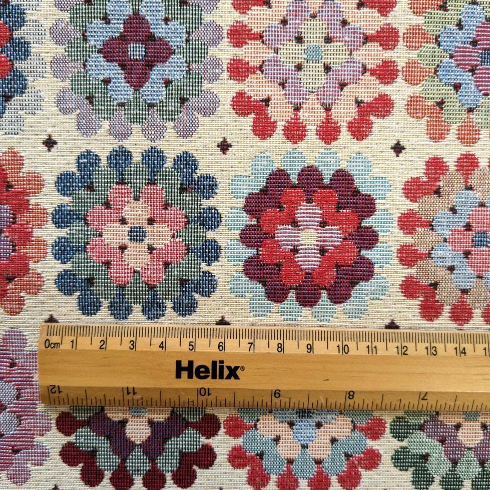 Multicolour tapestry fabric with a granny square design and a rule for scale