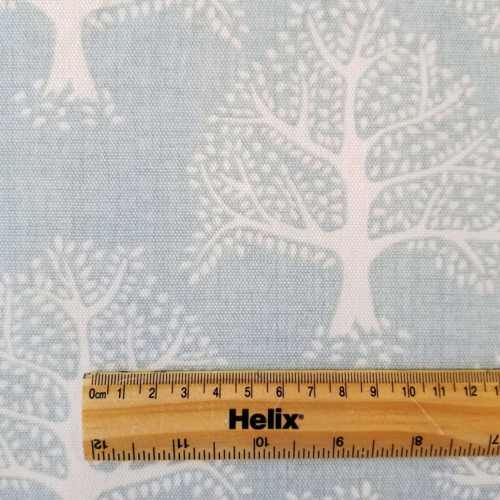Light Blue Fabric with a print of oak trees and and eco friendly badge