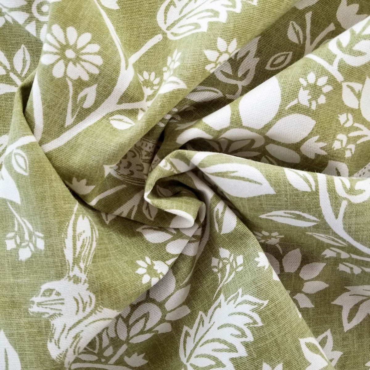 Printed curtain fabric with a design of hares and pheasants in cream on a green background