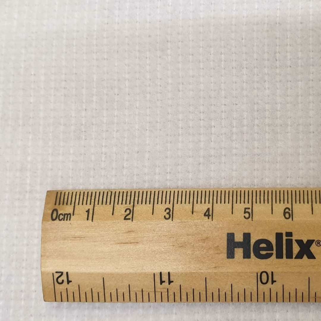 White curtain bump interlining lightweight polyester with rule for scale