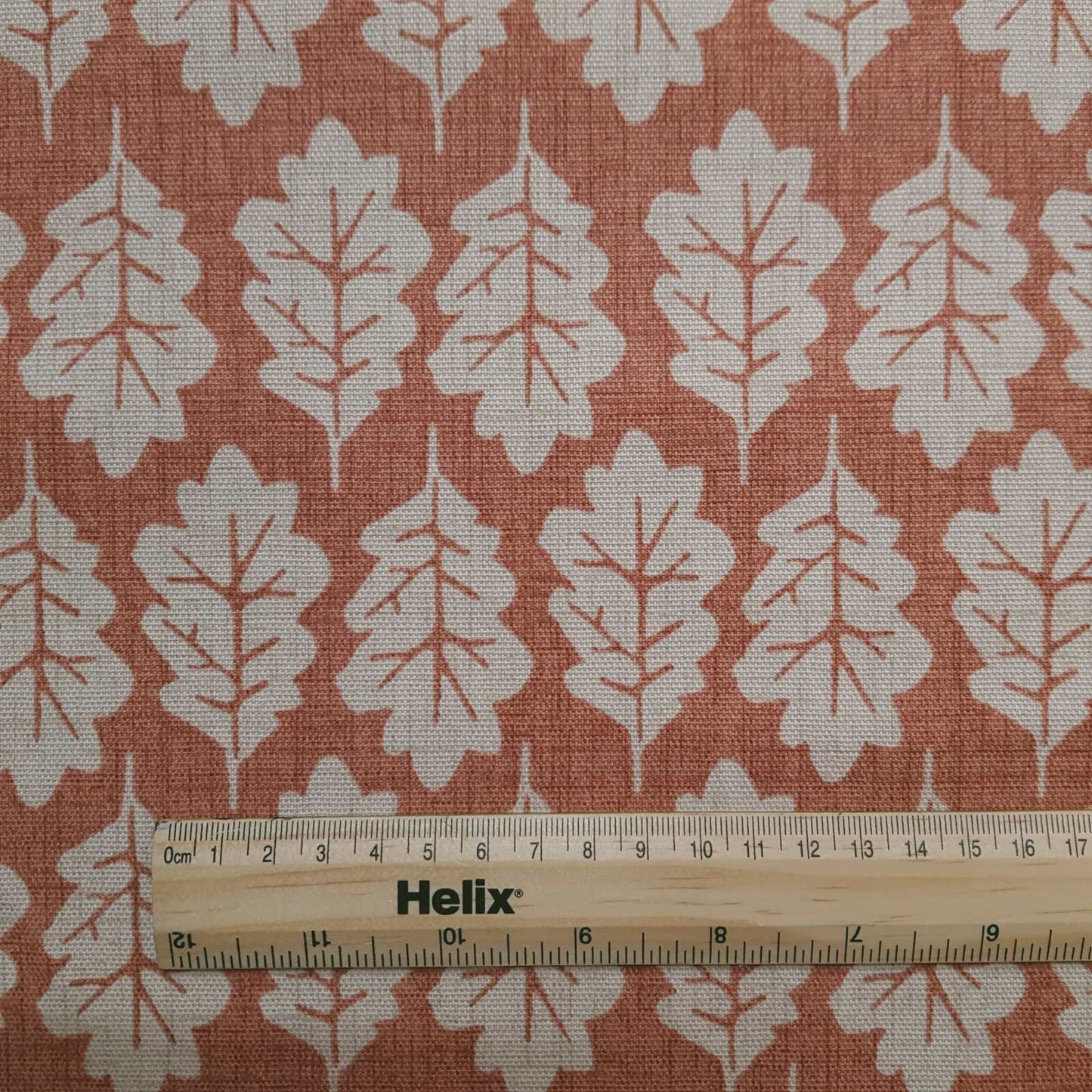 Leaf print fabric in terracotta with rule for scale