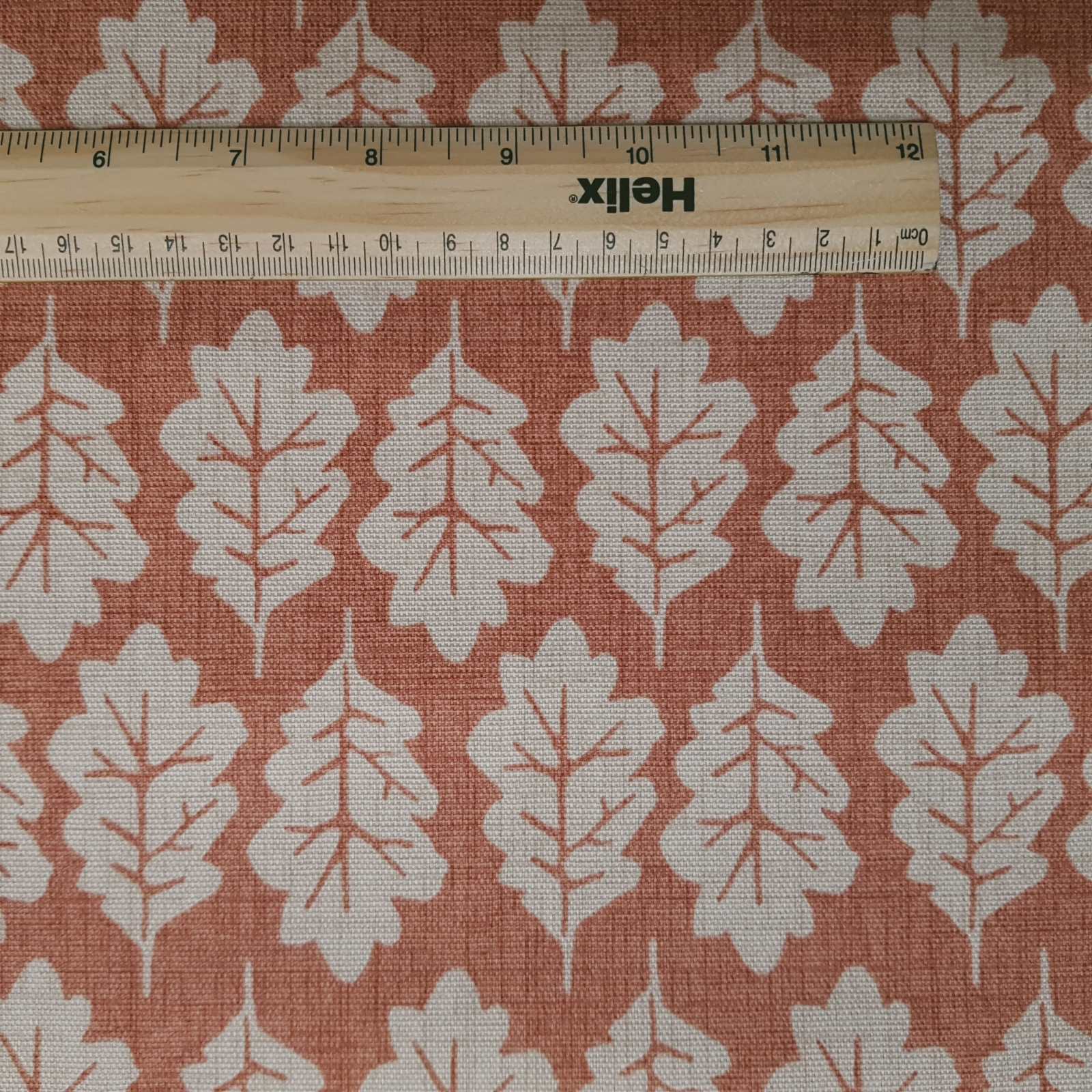 Leaf print fabric in terracotta with rule for scale