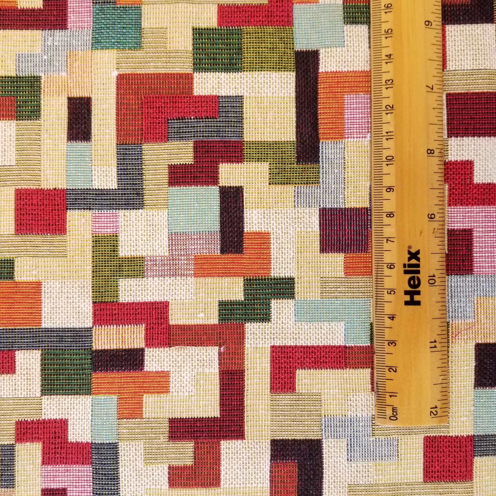 Tapestry fabric with a rule showing scale of multicolour tetris design